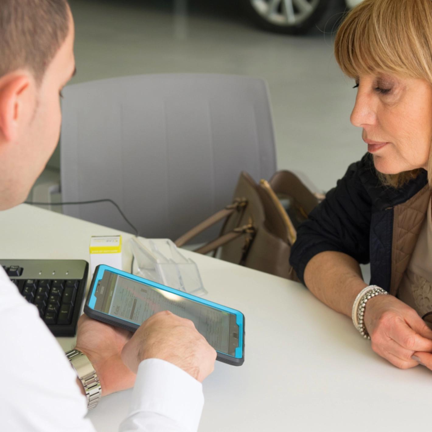 Dipendente Clinic Grandine mostra l'avanzamento lavori sullo smartphone al cliente