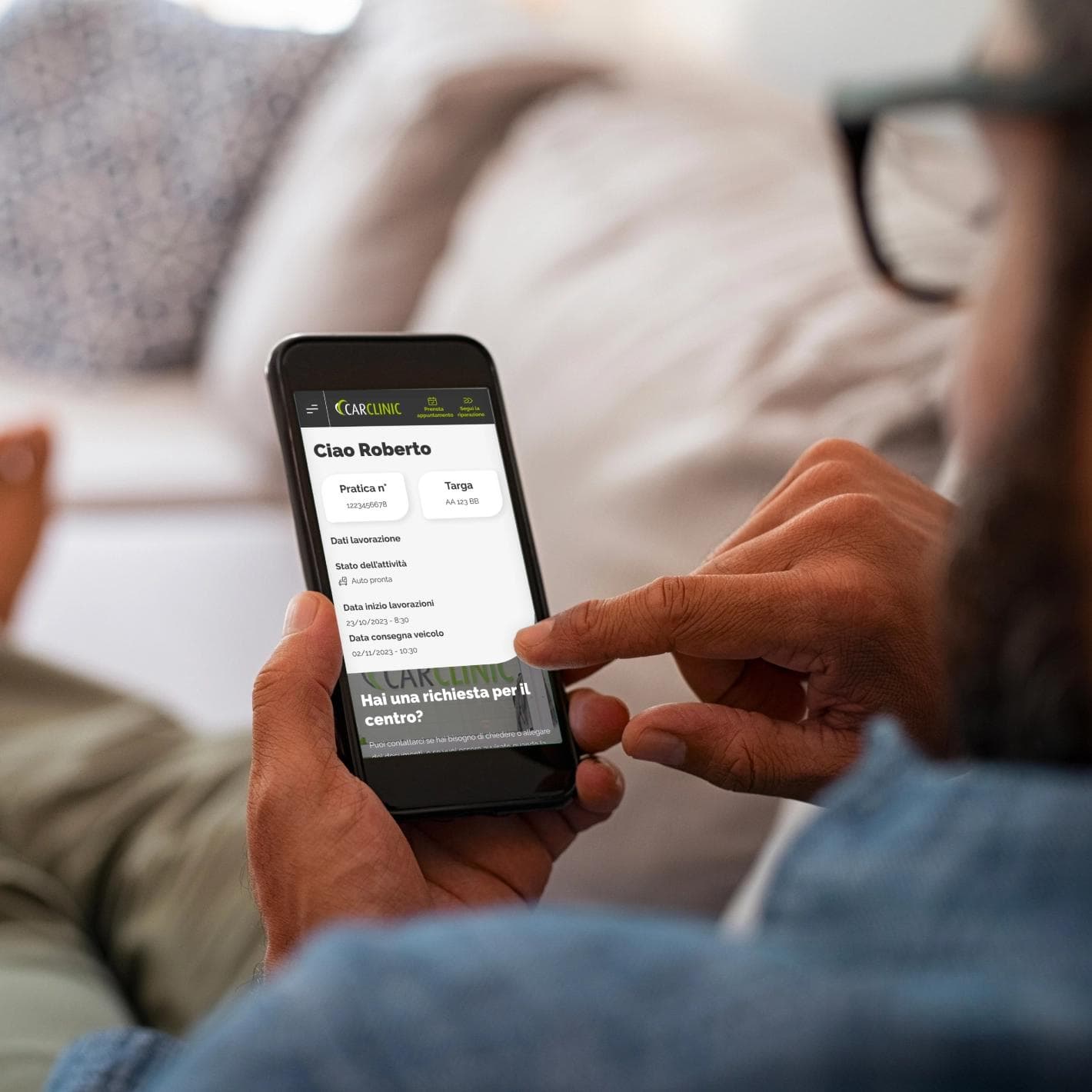 Dettaglio di una persona che segue le fasi della riparazione del suo veicolo direttamente dal suo smartphone